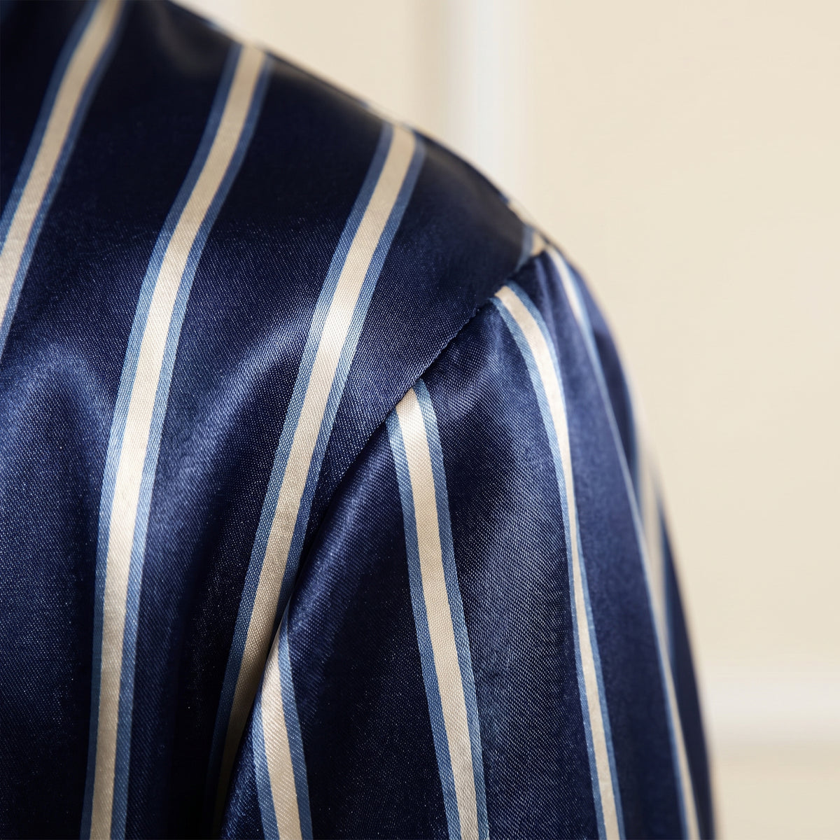 Détail des rayures crème sur le satin bleu marine brillant