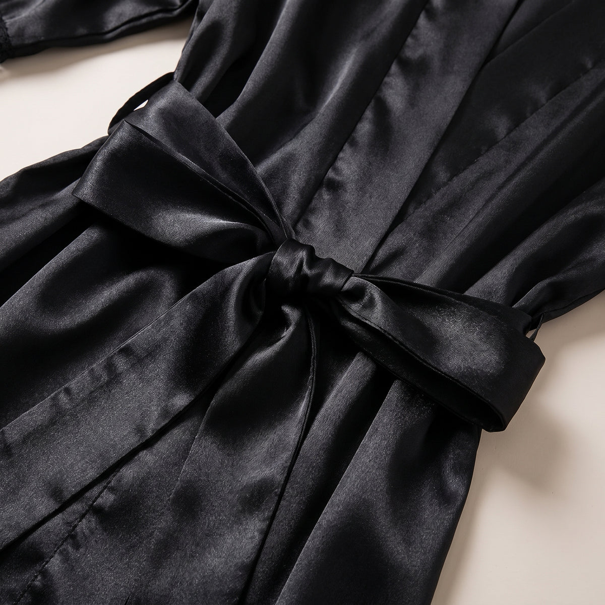 Détail de la ceinture nouée et du satin noir brillant