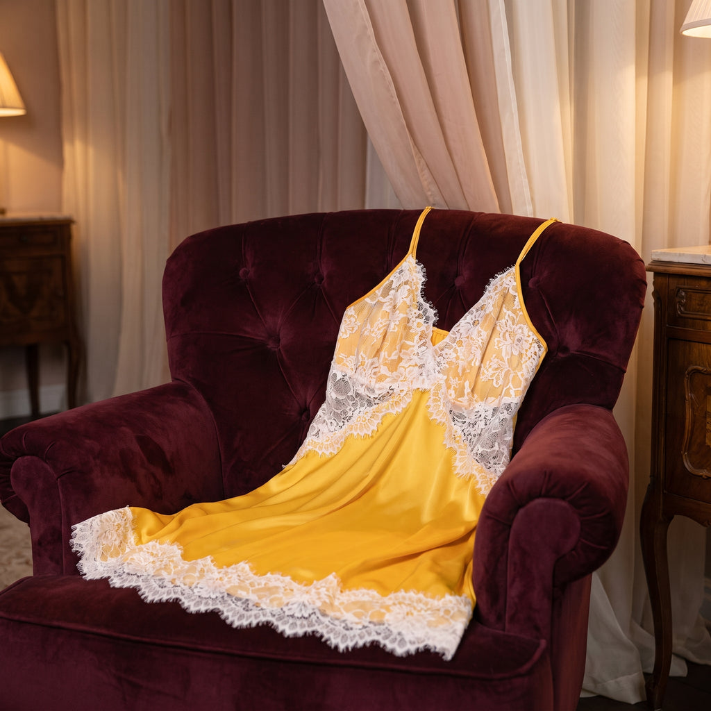 Nuisette jaune posée sur un fauteuil dans un boudoir le soir