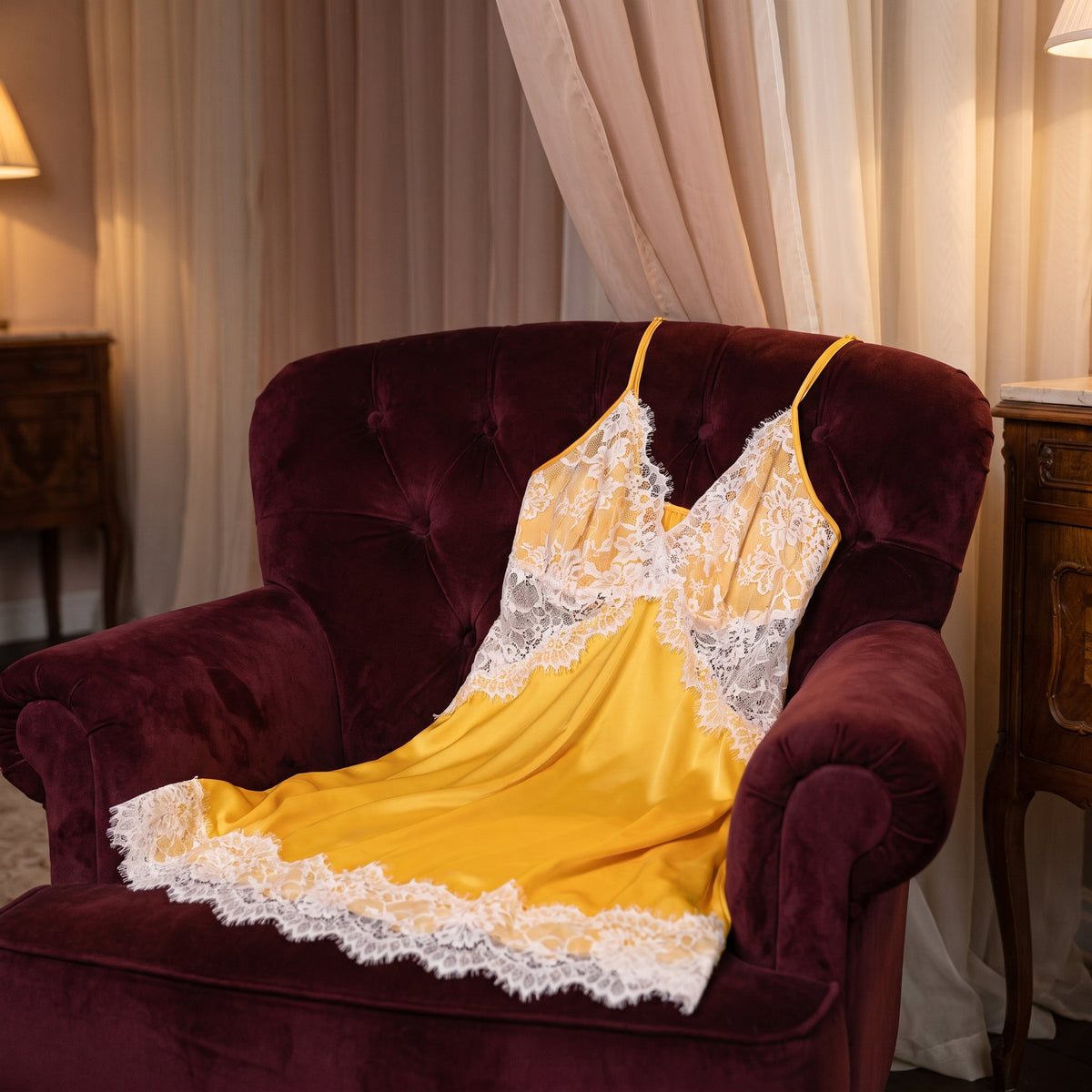 Nuisette jaune posée sur un fauteuil dans un boudoir le soir