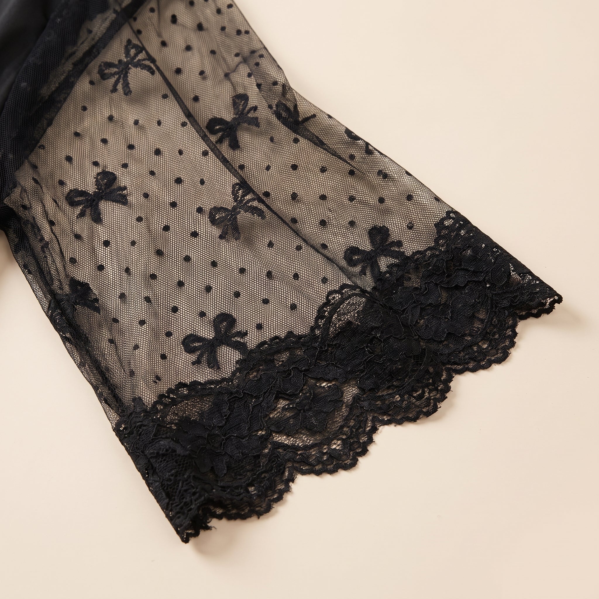 Détail de la manche du kimono en voile noir à pois bordée de dentelle Image
