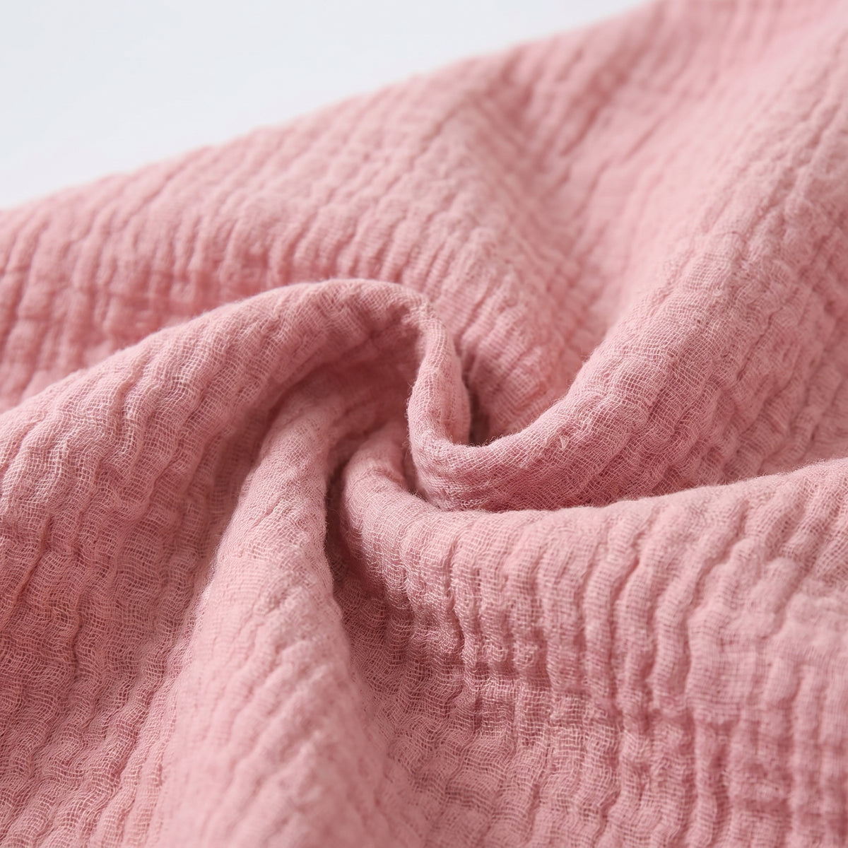 Détail de la matière en double gaze de coton rose, froissée et aérée