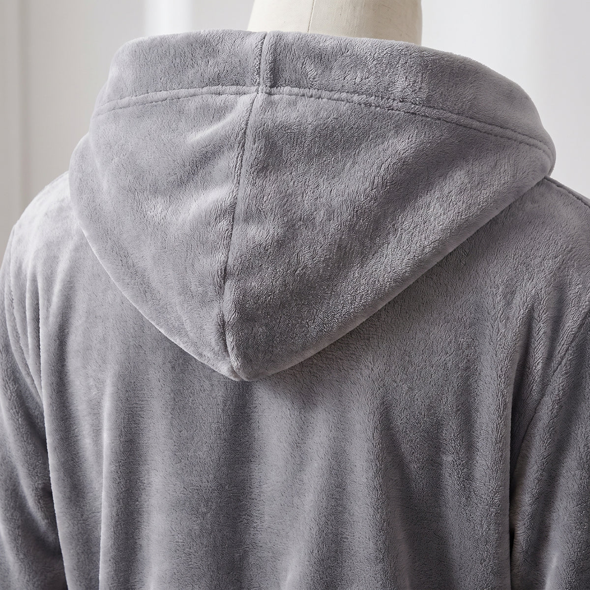 Détail de la grande capuche doublée du peignoir homme en maille polaire grise, vue de dos
