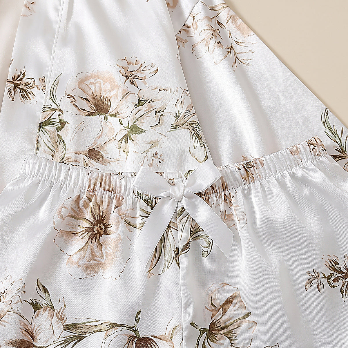 Détail de la taille élastiquée et du noeud du short en satin blanc floral