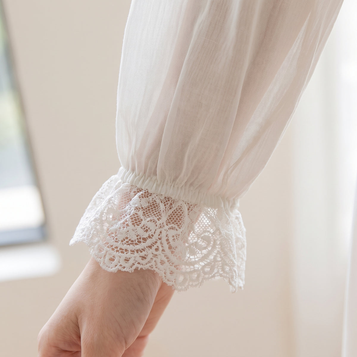 Détail du poignet à volant de dentelle blanche
