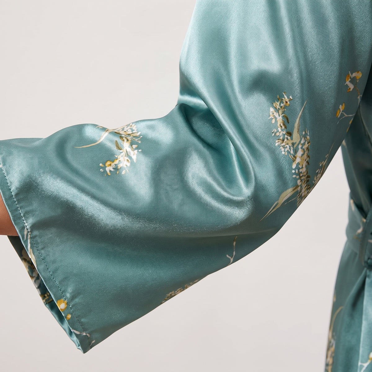 Détail du satin vert céladon chatoyant et du semis floral de la manche kimono