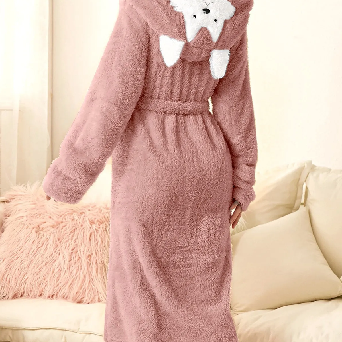 Robe de chambre rose à capuche animal disposée dans un boudoir Image