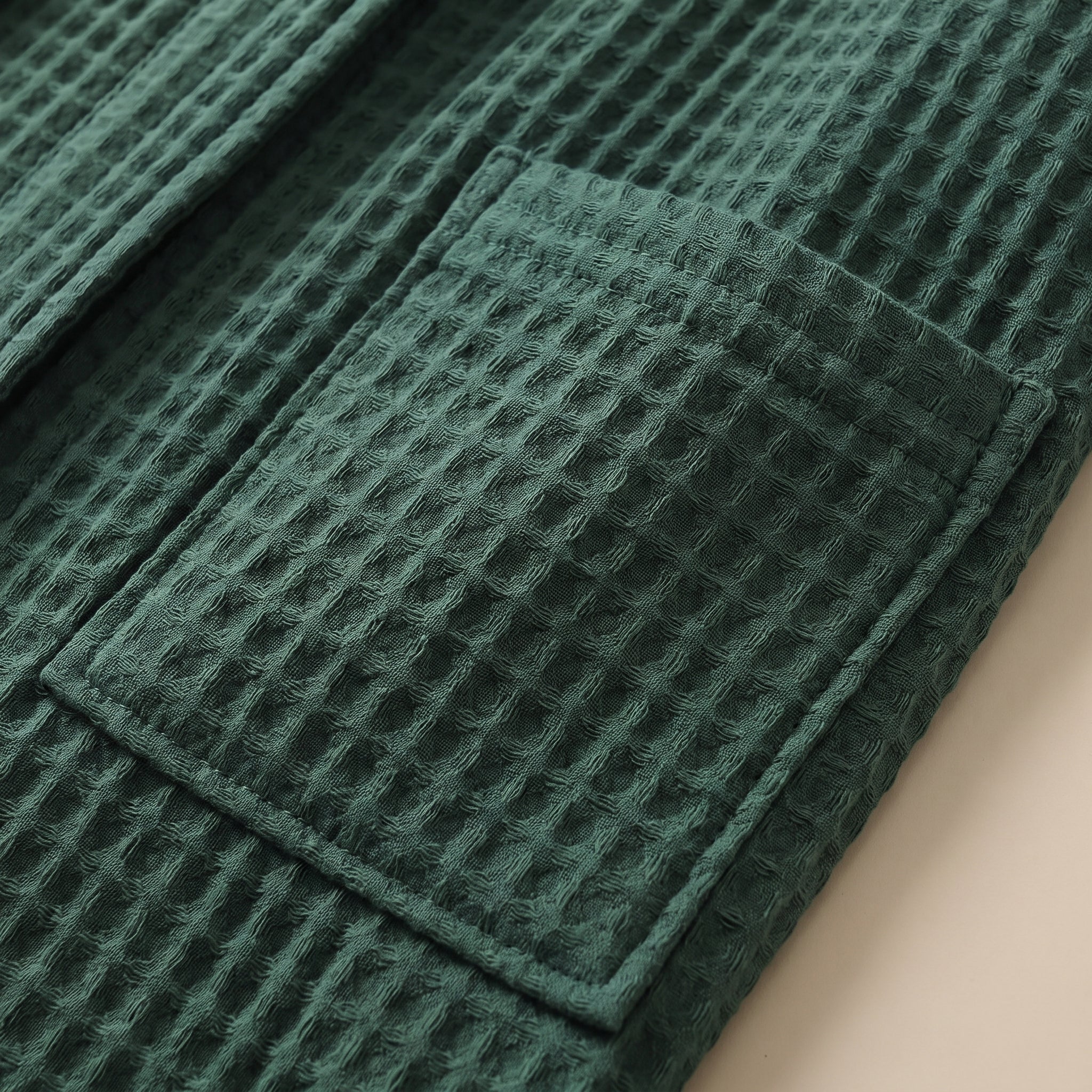 Détail d'une poche plaquée et de la maille nid d'abeille du peignoir vert sapin Image