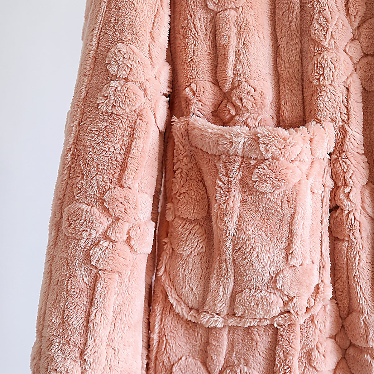 Détail de la flanelle rose à motif floral en relief et de la poche plaquée