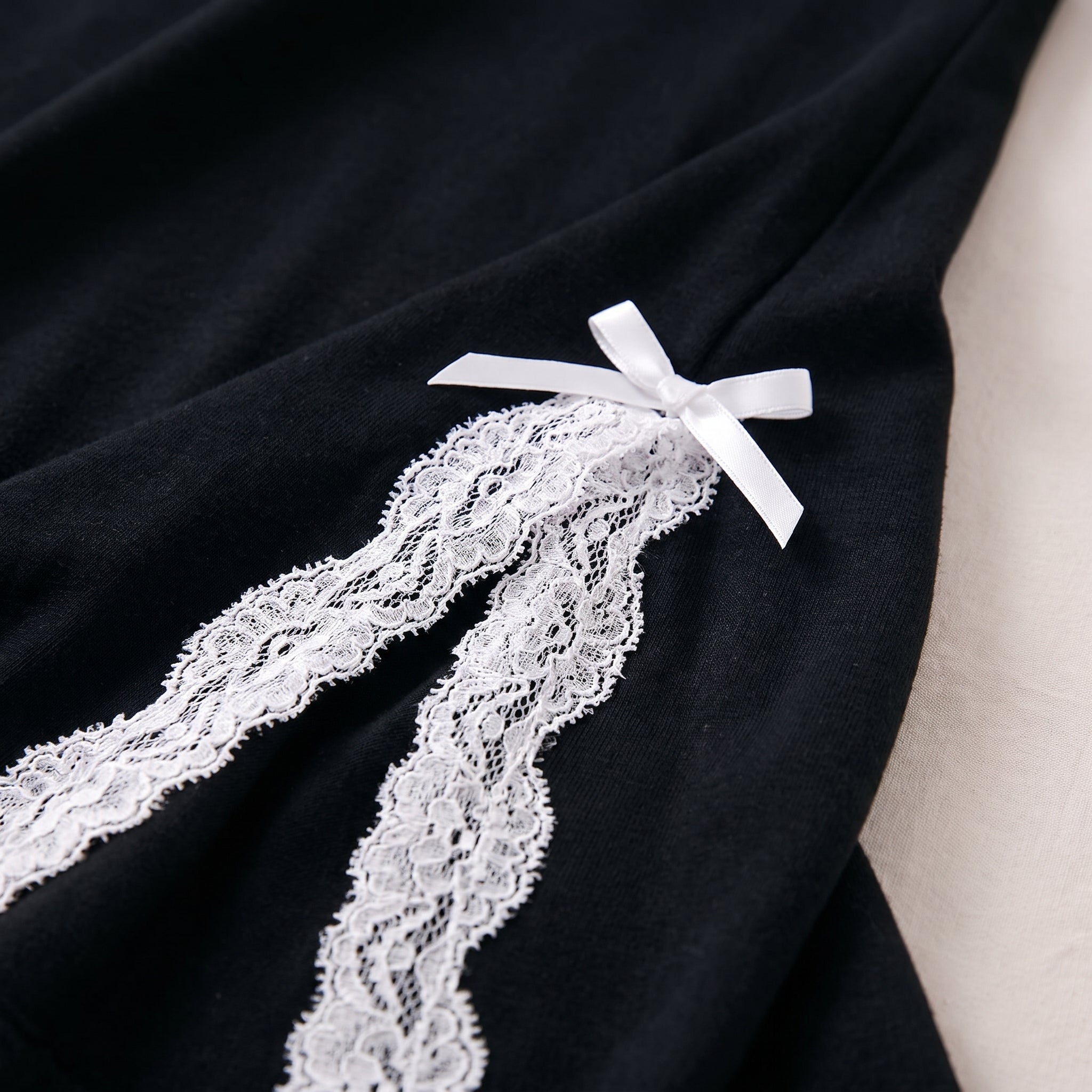 Détail de la fente latérale bordée de dentelle blanche et du noeud Image