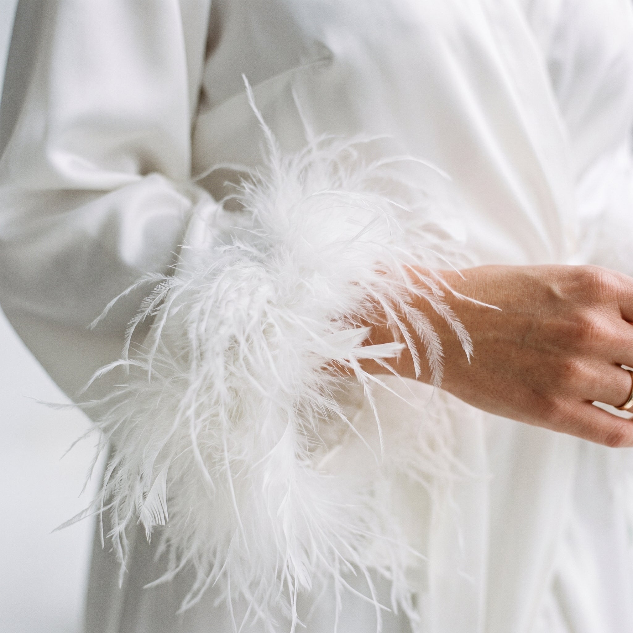 Gros plan plumes blanches et satin de la robe de chambre Image