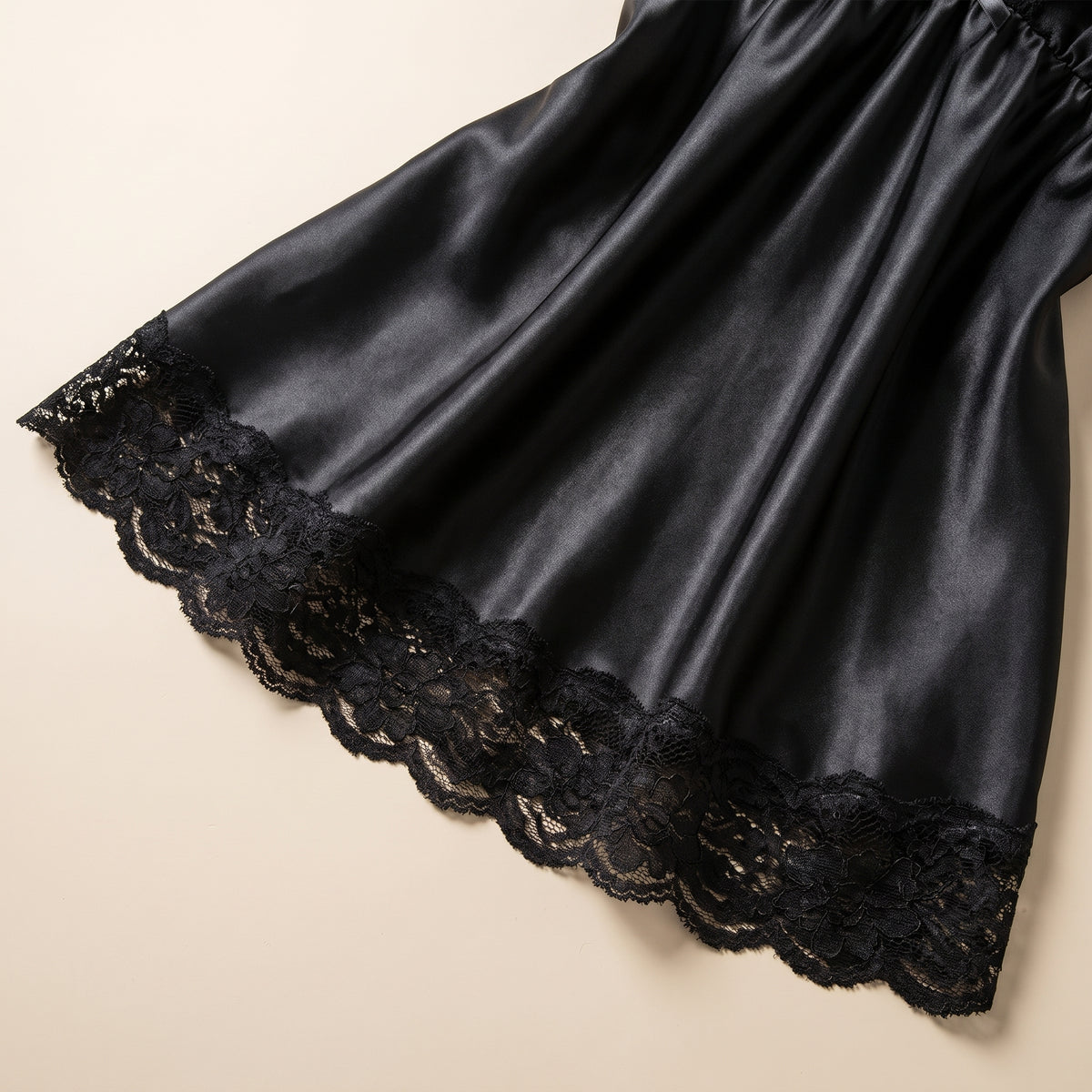 Détail de l'ourlet en dentelle et du satin noir de la jupe