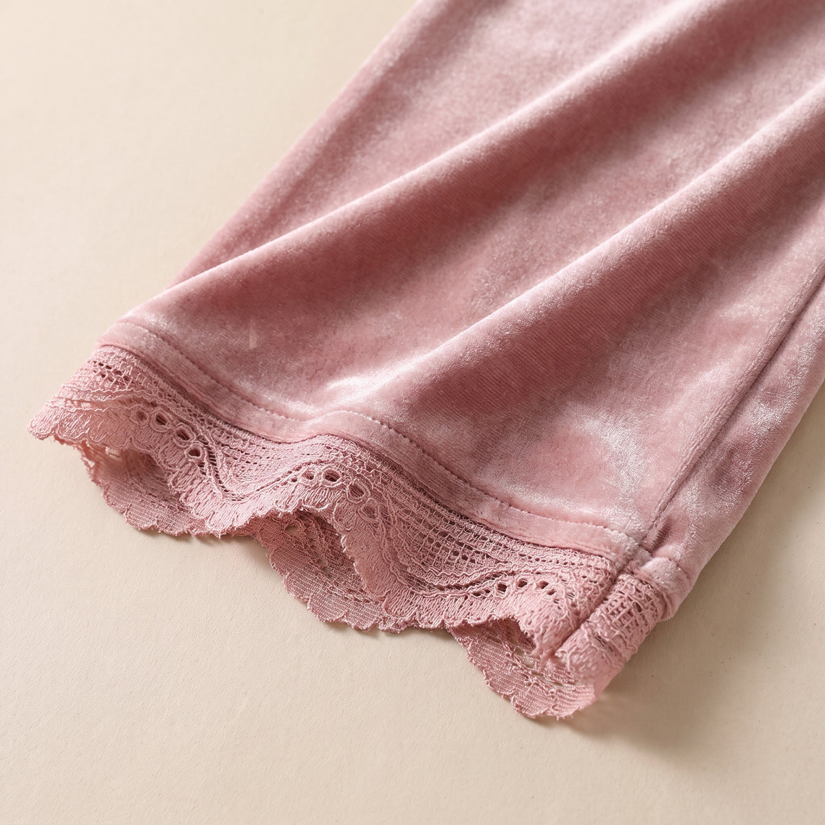 Détail du velours rose et de l'ourlet à dentelle festonnée