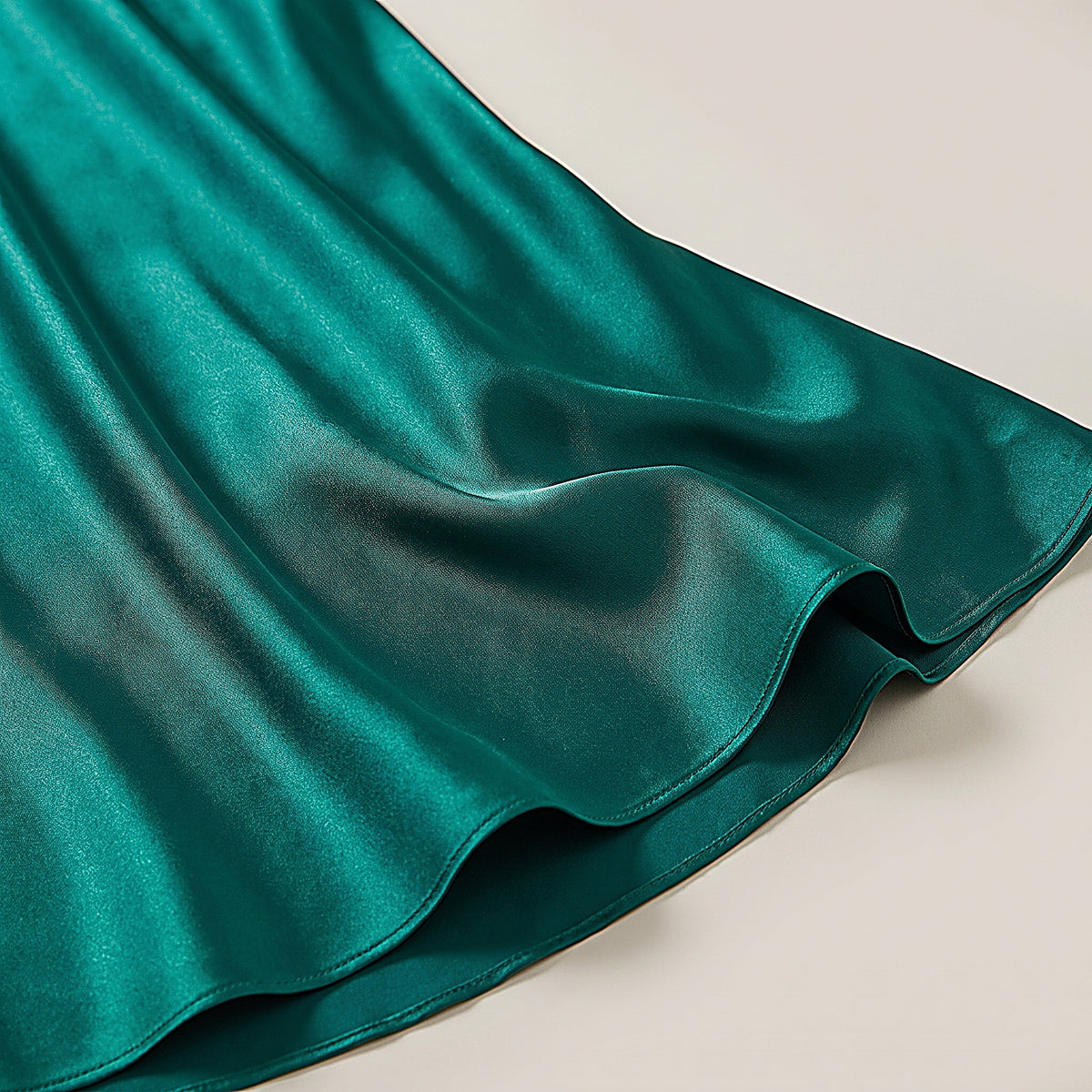 Détail du satin vert émeraude fluide et chatoyant