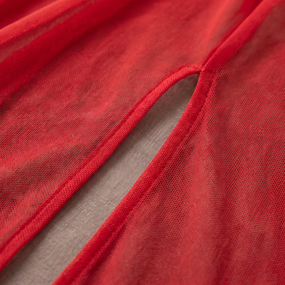 Détail du mesh rouge transparent et de la fente de la longue jupe