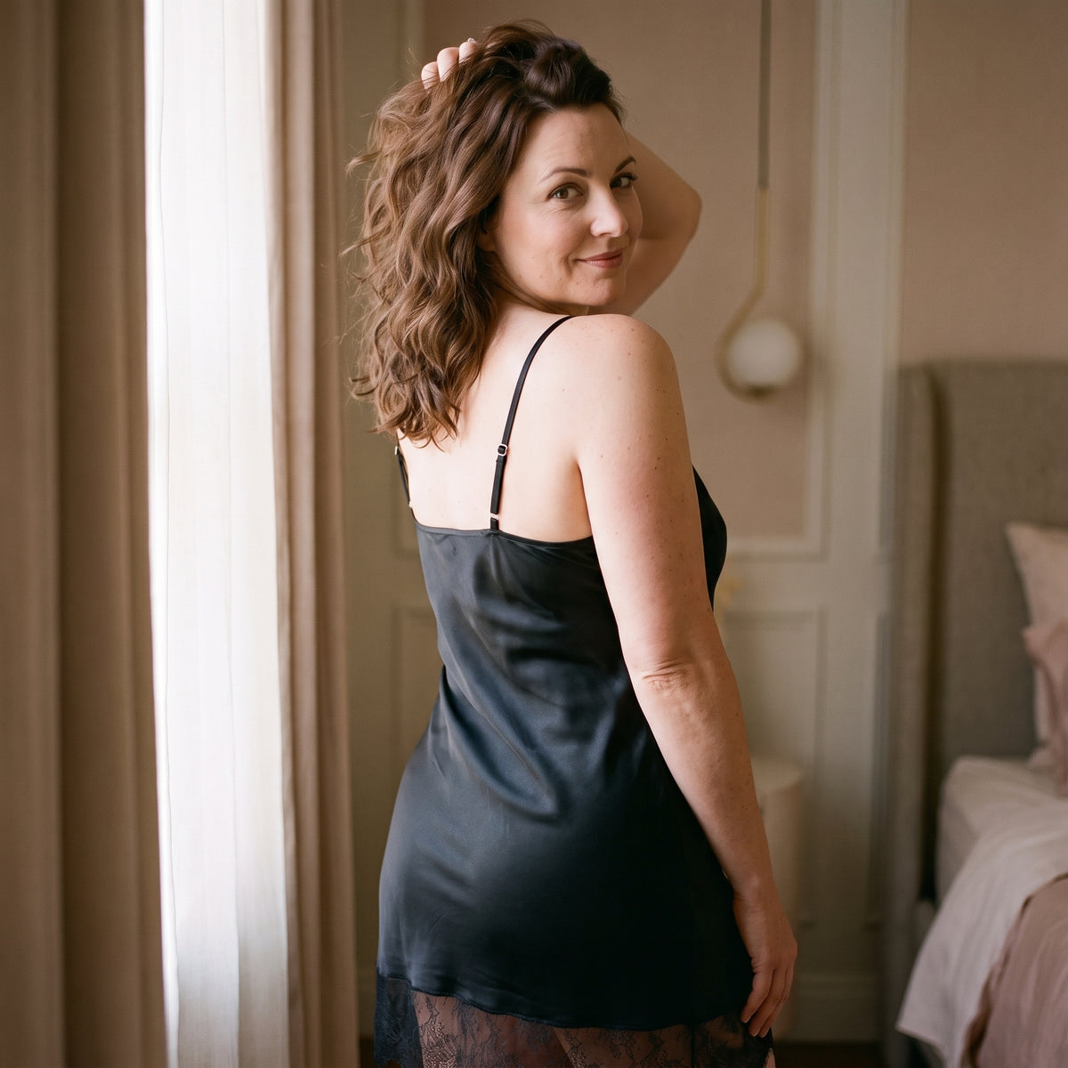 Nuisette noire vue de dos, bordure droite du dos en satin et bretelle réglée par sa coulisse