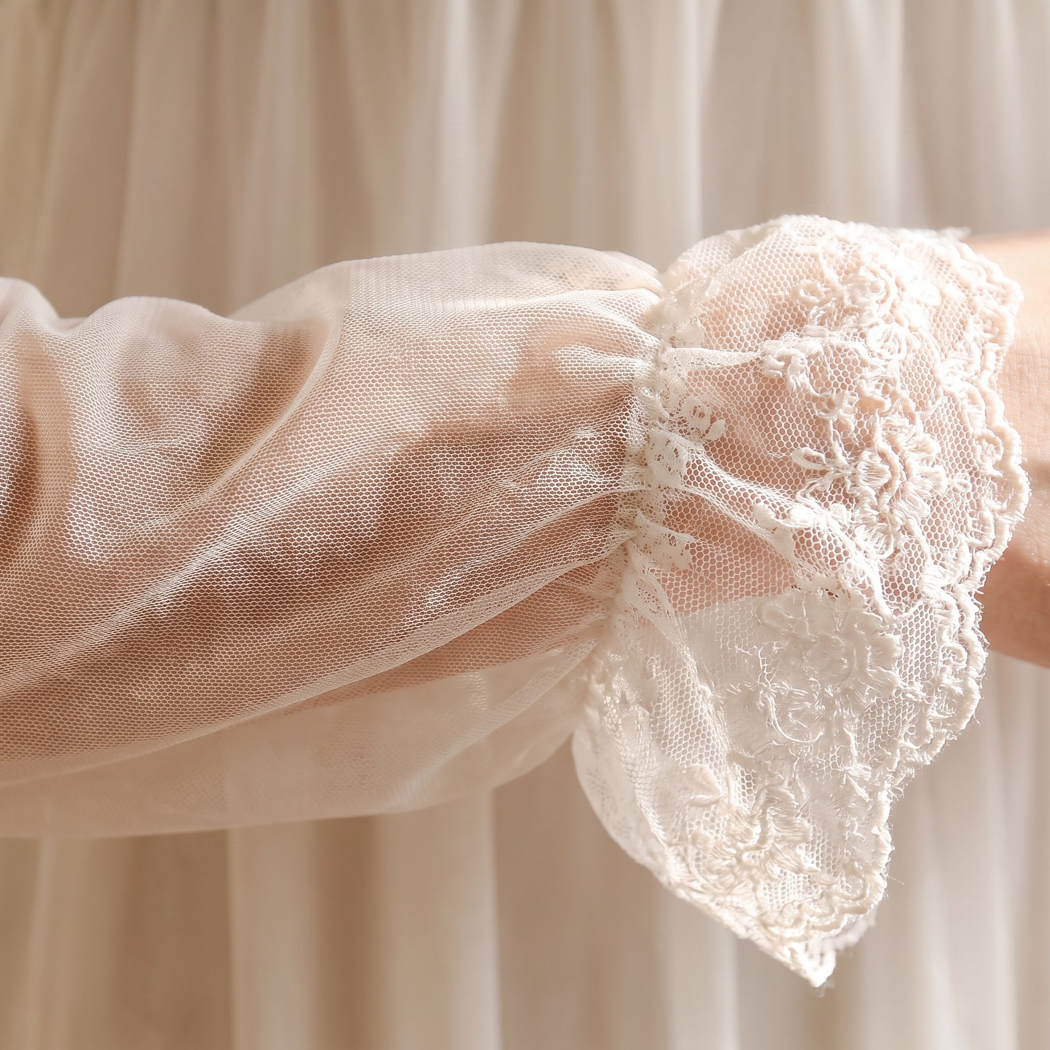 Détail de la manche en voile et du poignet à volant de dentelle Image