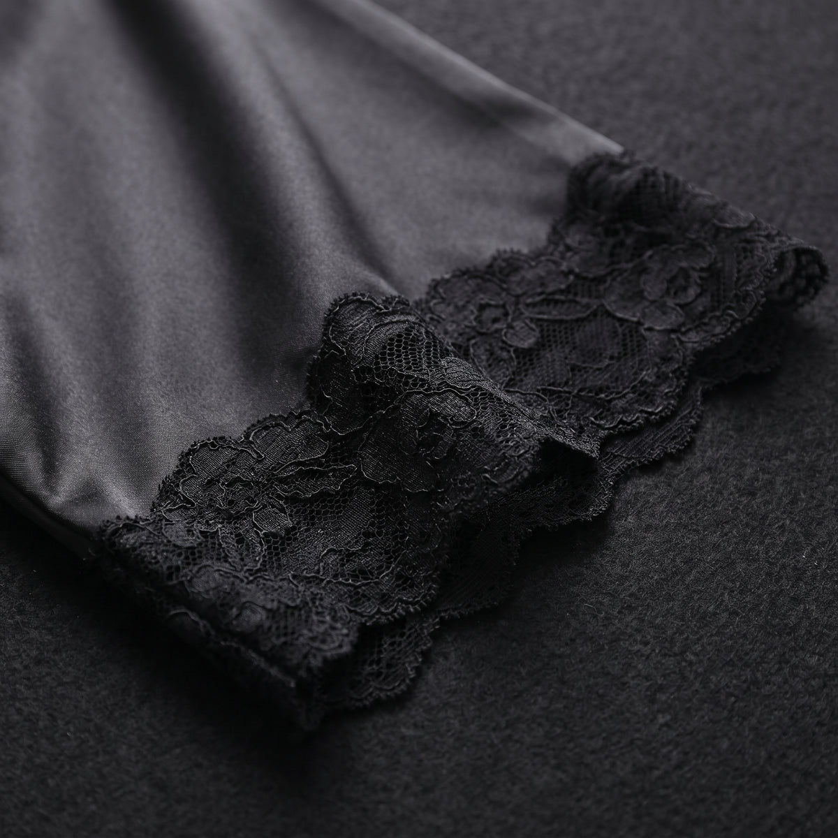 Détail de la manche du kimono en satin noir bordée de dentelle