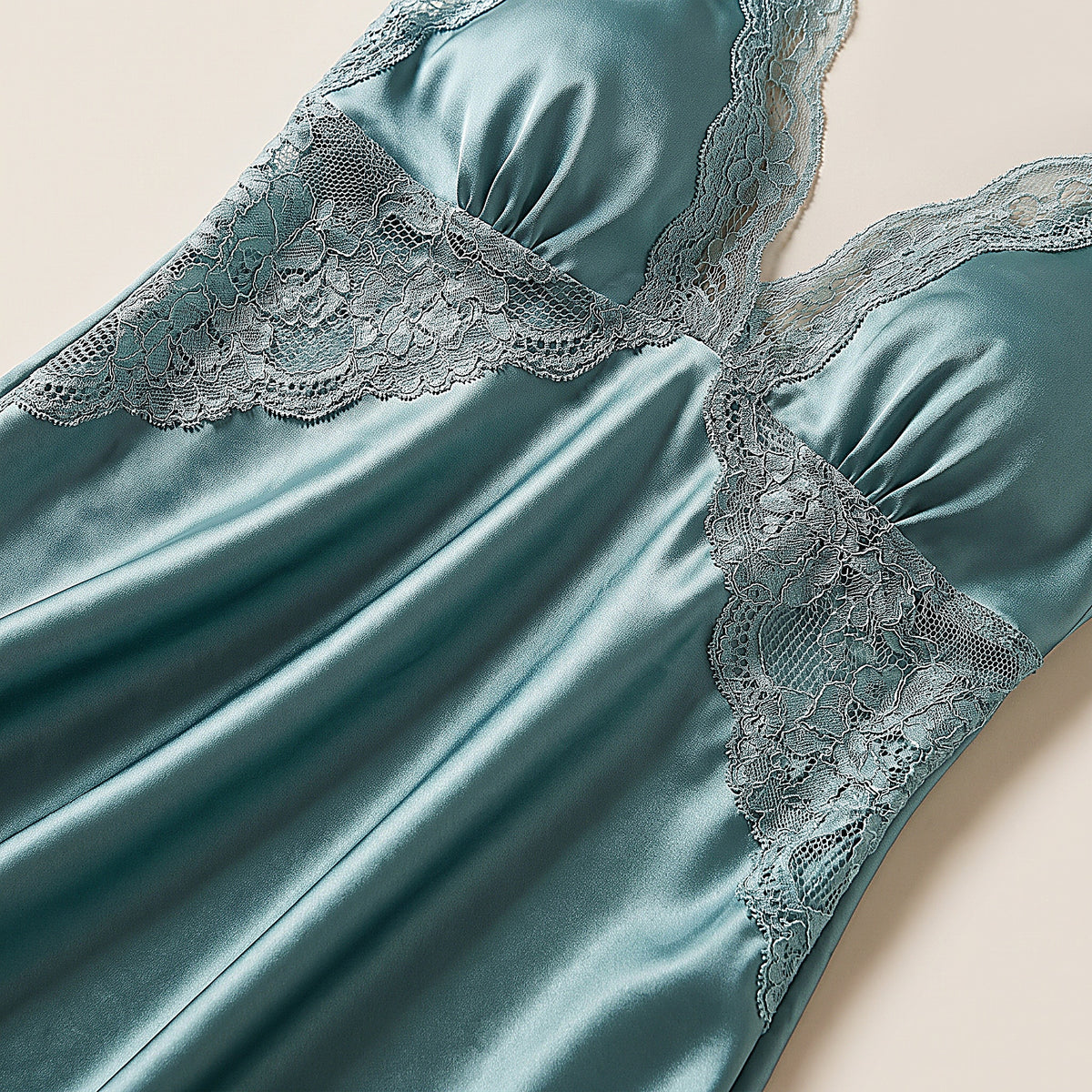 Détail du satin bleu vert et de l'empiècement de dentelle sous le buste