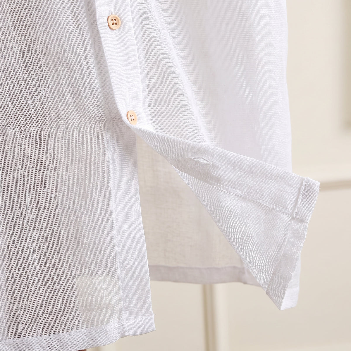 Détail de la matière gaze de coton blanche et de la fente latérale