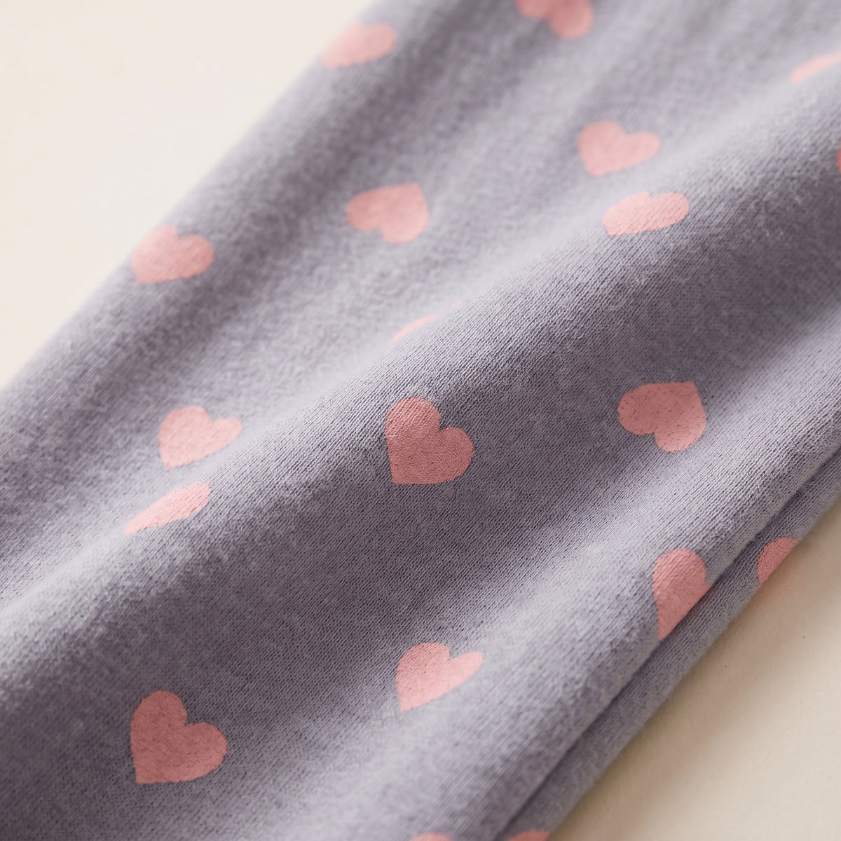 Détail du coton gris à imprimé coeurs roses