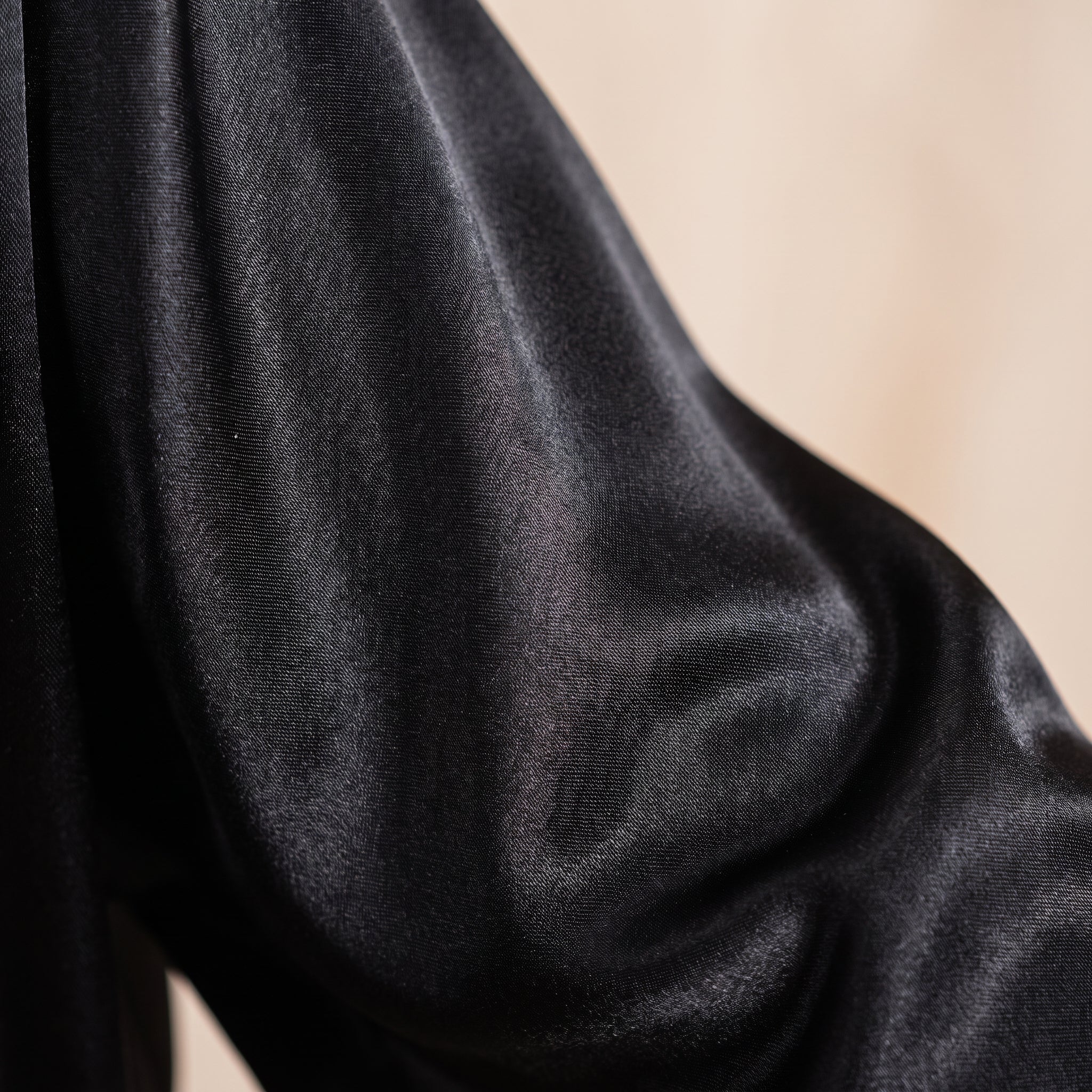 Détail du satin noir chatoyant de la manche du peignoir Image