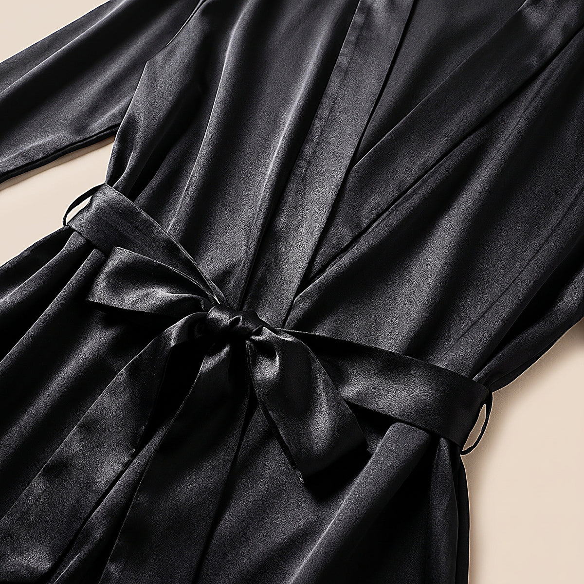 Détail du satin noir de la robe et de sa ceinture nouée