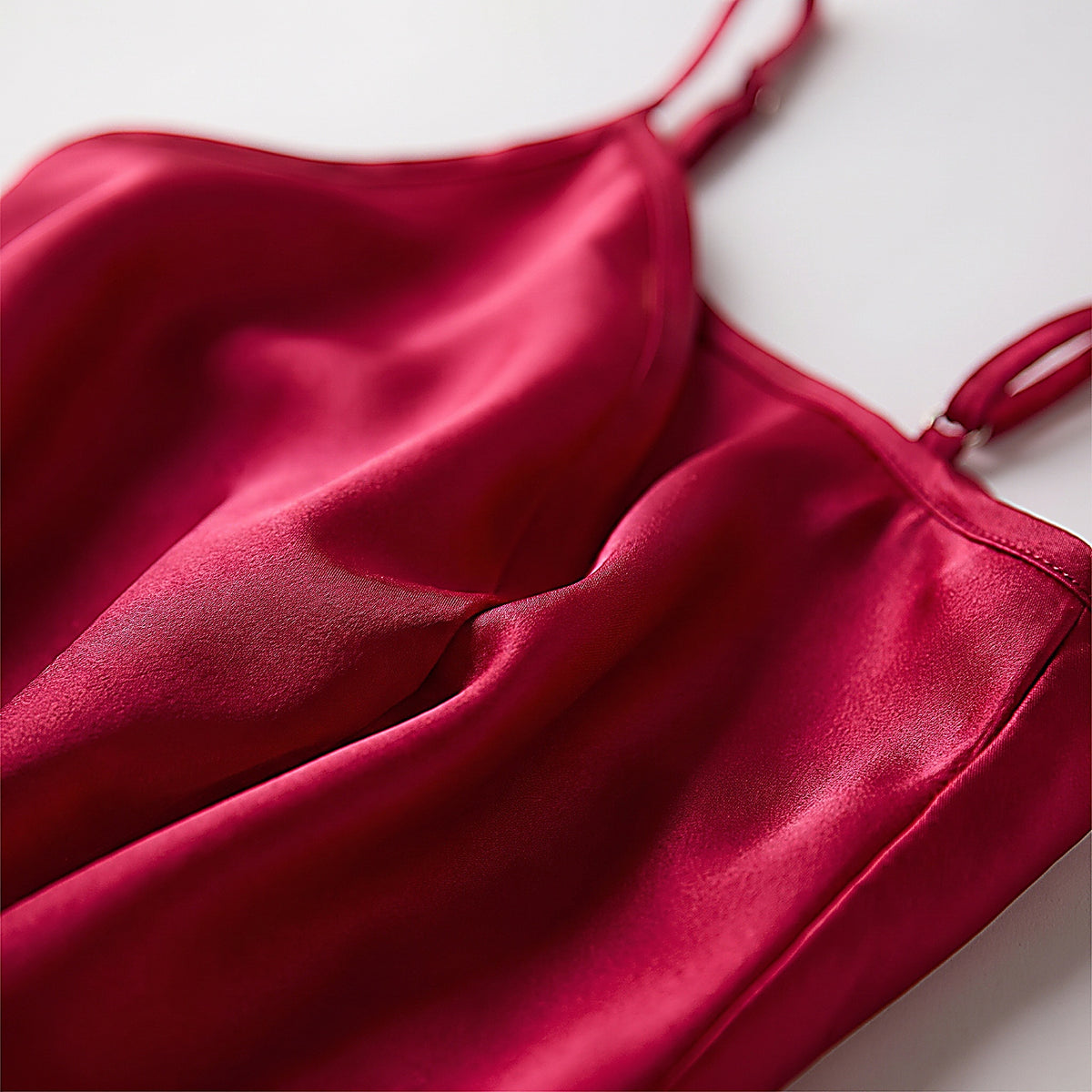 Détail du satin rouge fluide et chatoyant de la nuisette