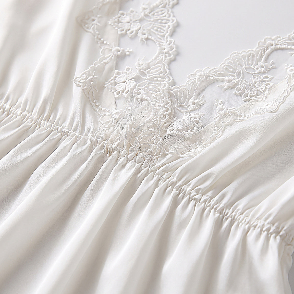 Détail du dos en dentelle brodée de la nuisette satin blanc