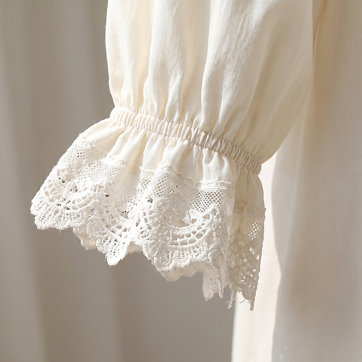 Détail du poignet à volant de dentelle blanche