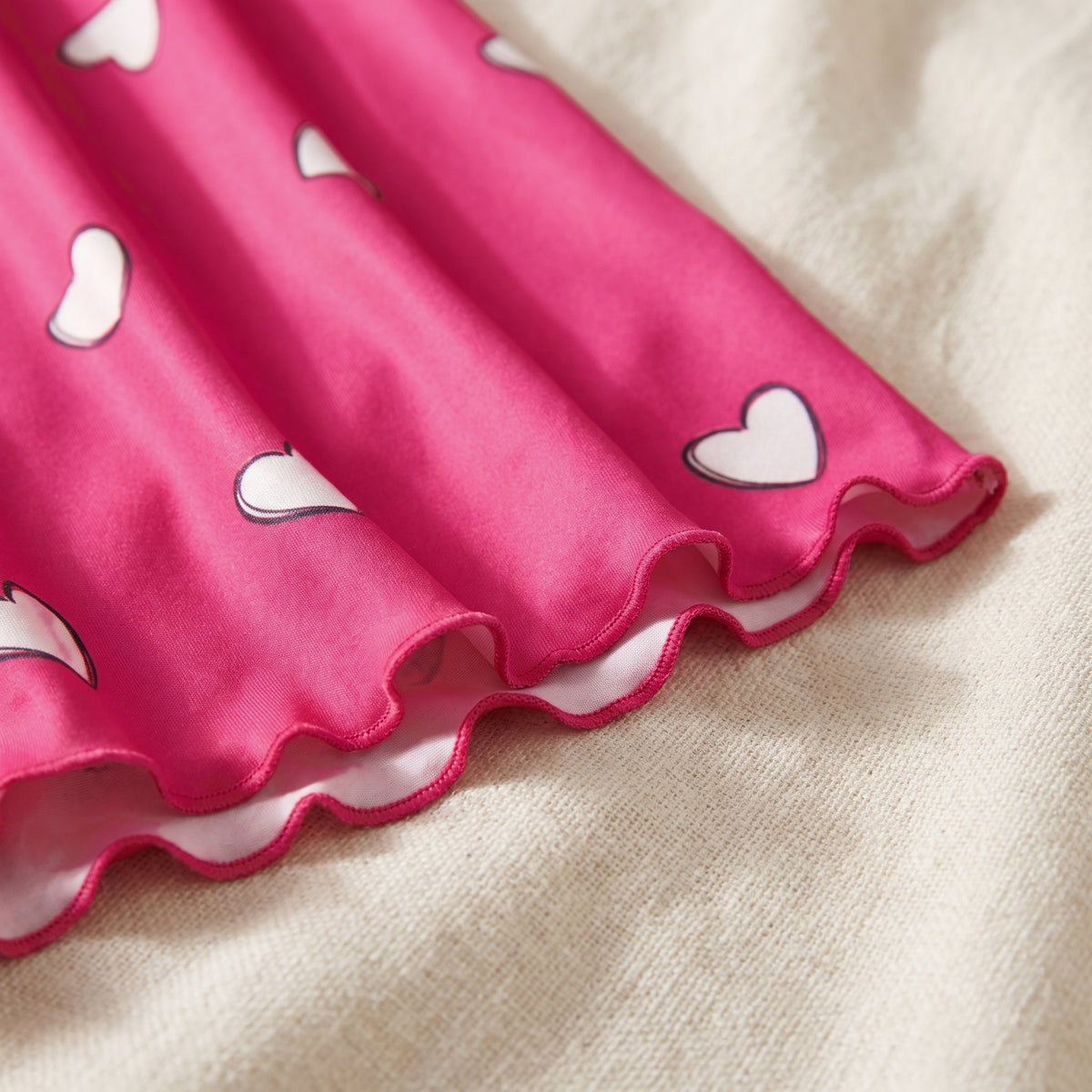 Ourlet du bas ondulé de la nuisette rose, maille fluide posée en pli souple