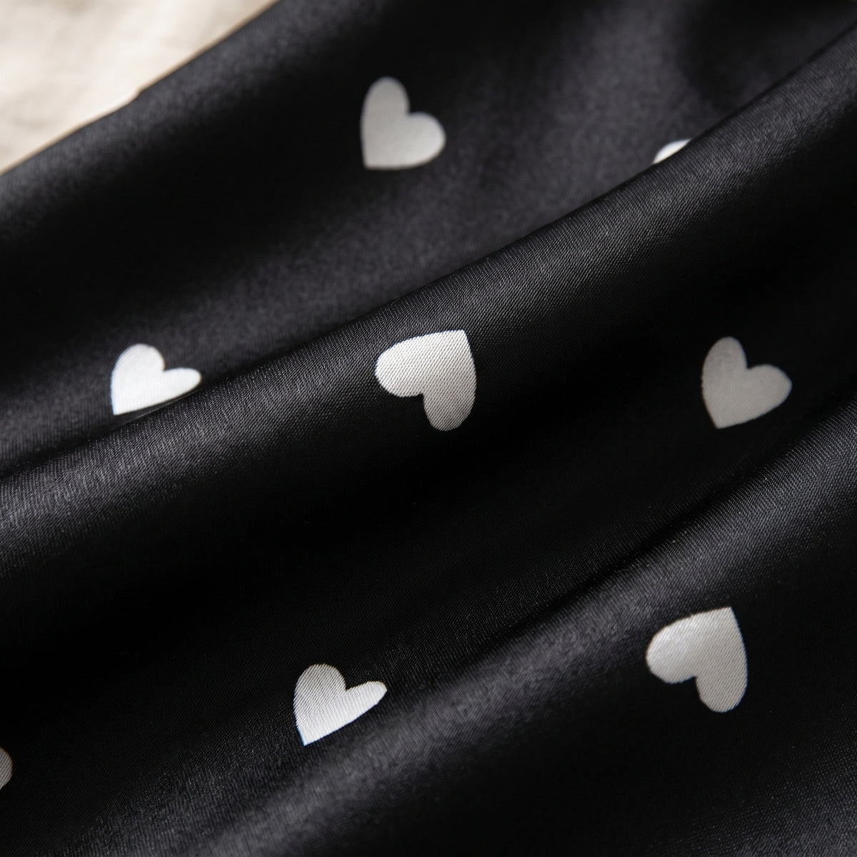 Les petits cœurs blancs semés sur le satin noir