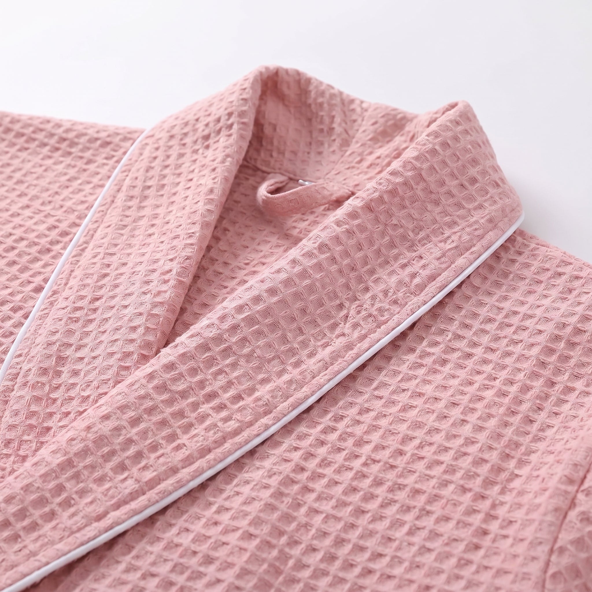 Détail du col châle bordé du fin passepoil blanc sur le coloris rose poudré Image
