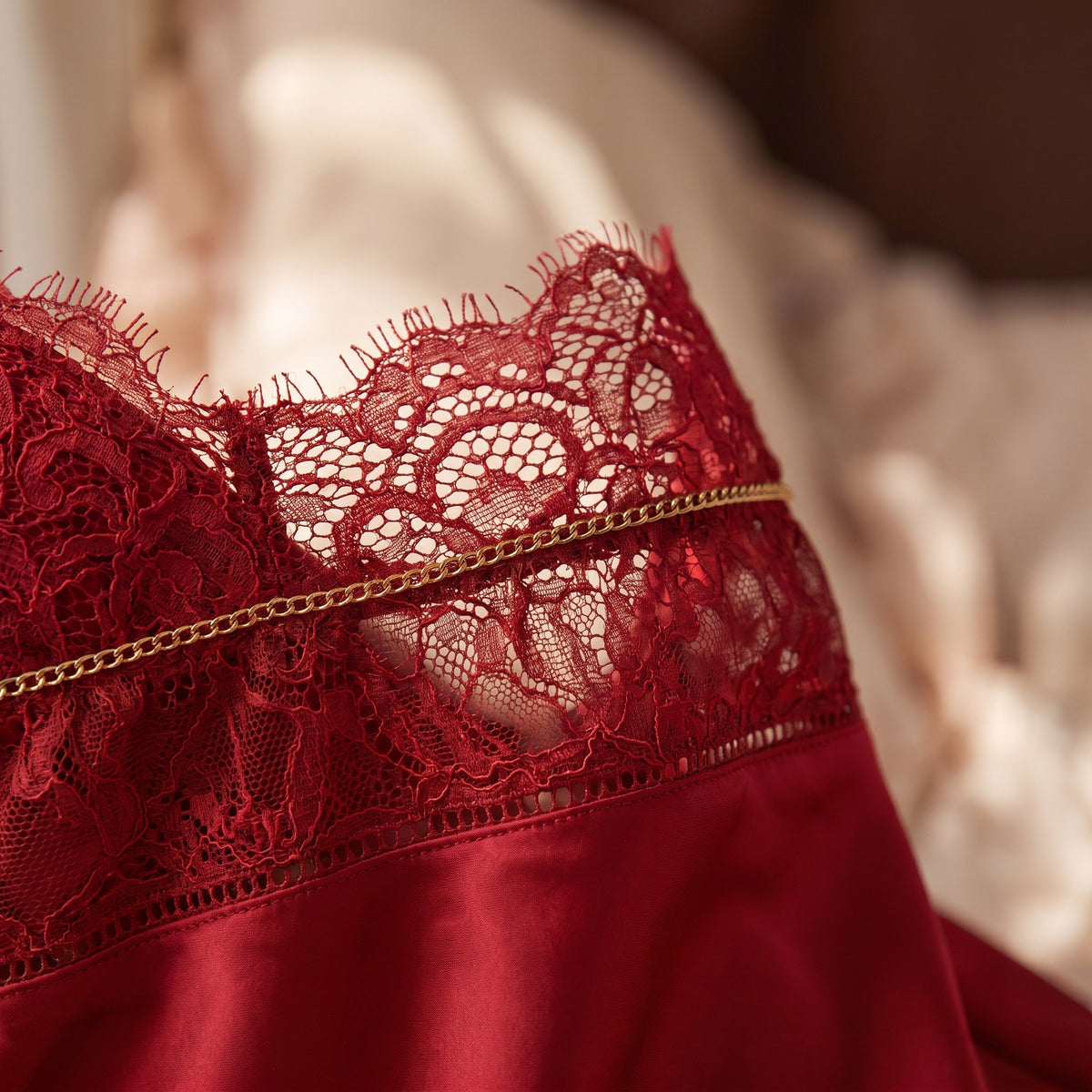 Le bustier de dentelle rouge et sa fine chaînette dorée