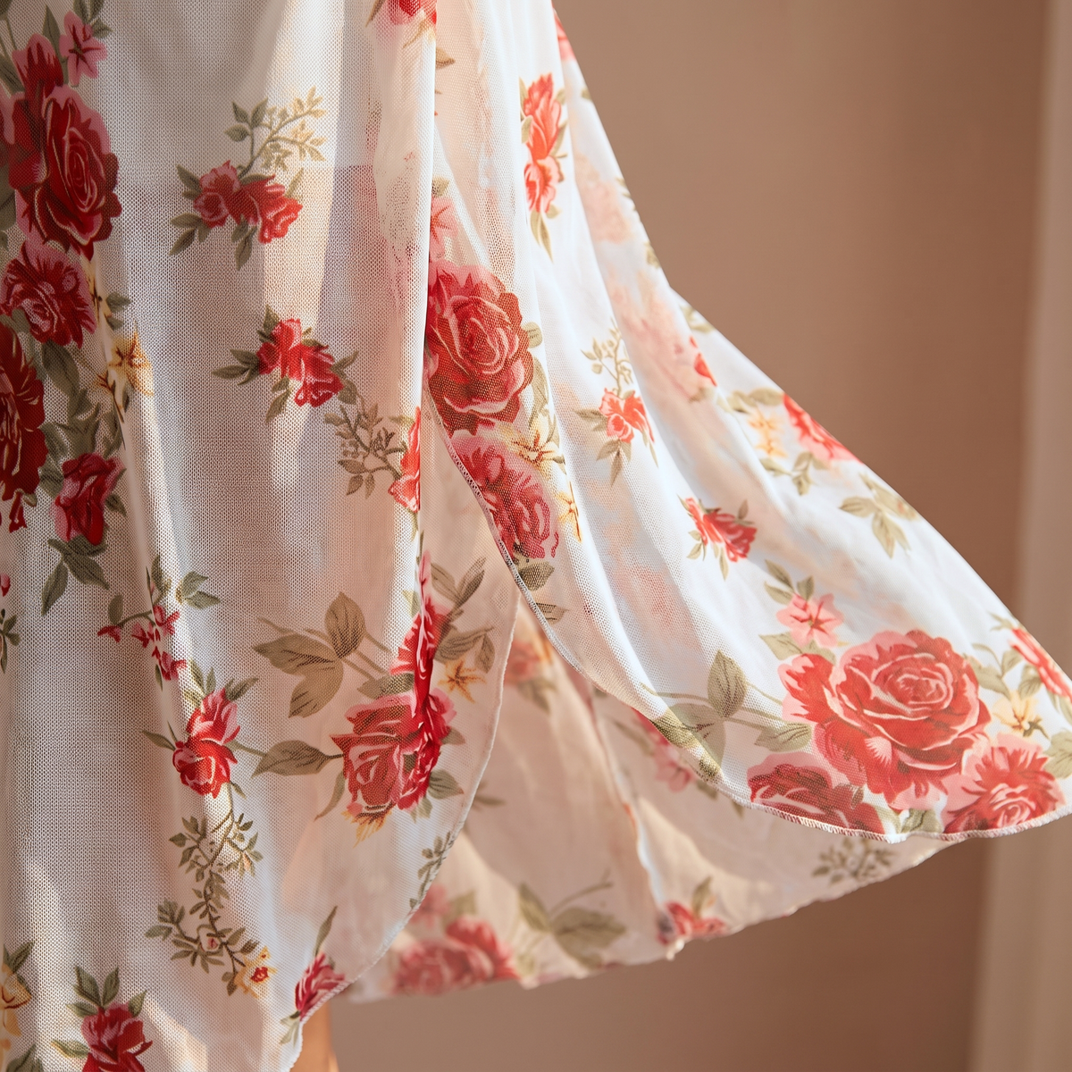 Ourlet en biais de la nuisette blanche fleurie, voile de maille imprimé en mouvement