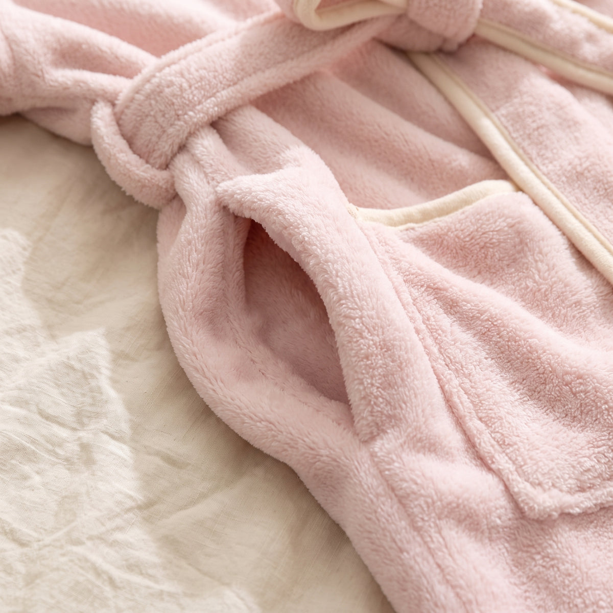Le poil court et dense du peignoir rose