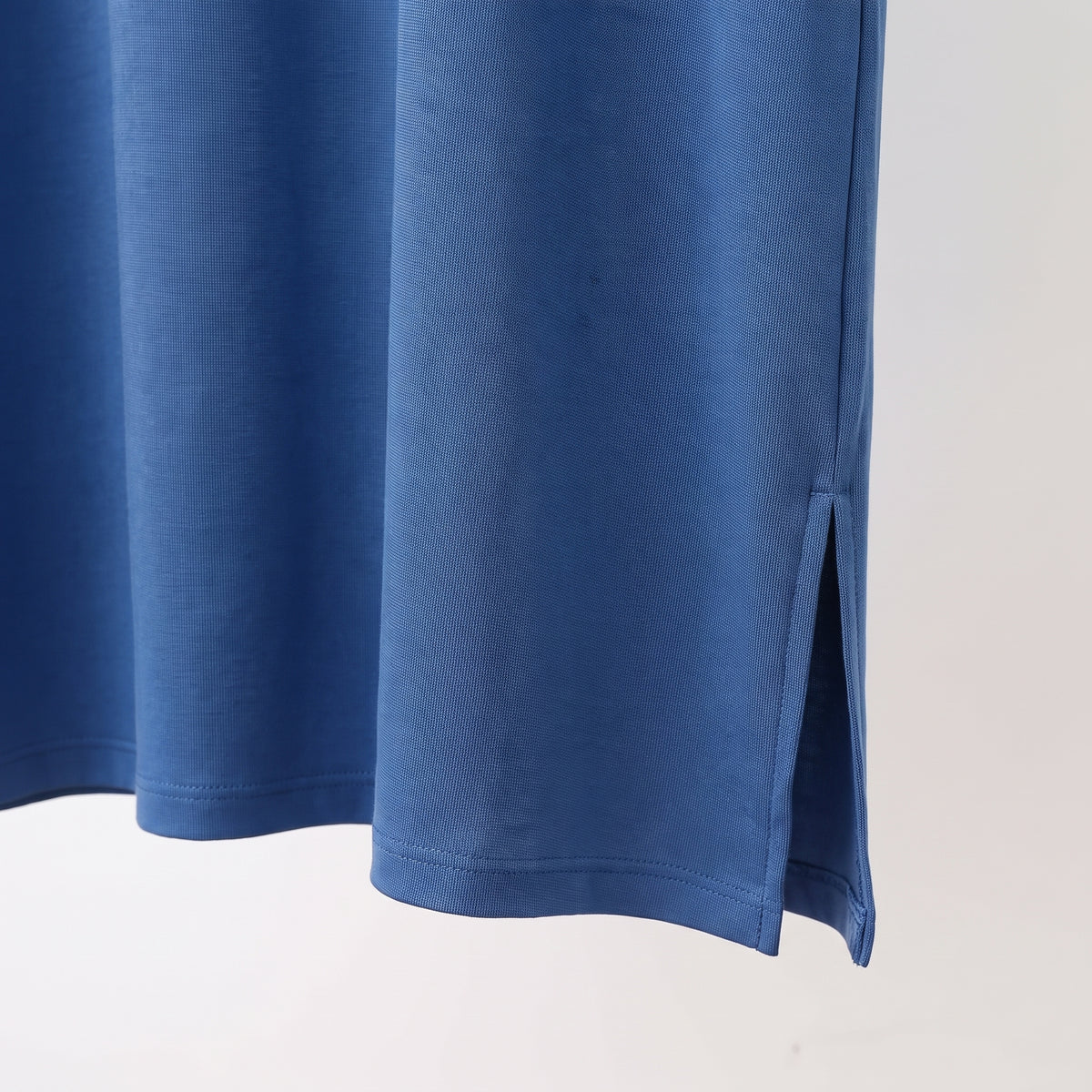 L'ourlet de la chemise de nuit bleue et sa fente latérale