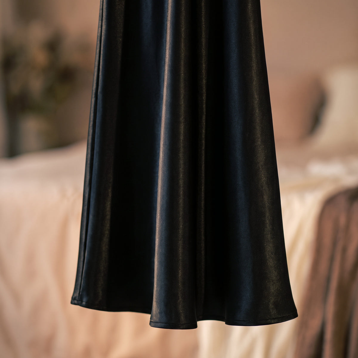 L'ourlet de la nuisette longue en satin noir, jupe évasée au tombé souple