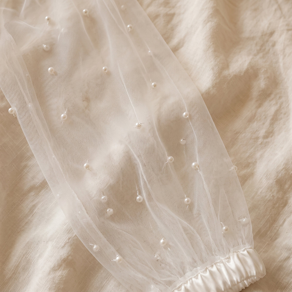 Les perles semées sur le tulle des manches