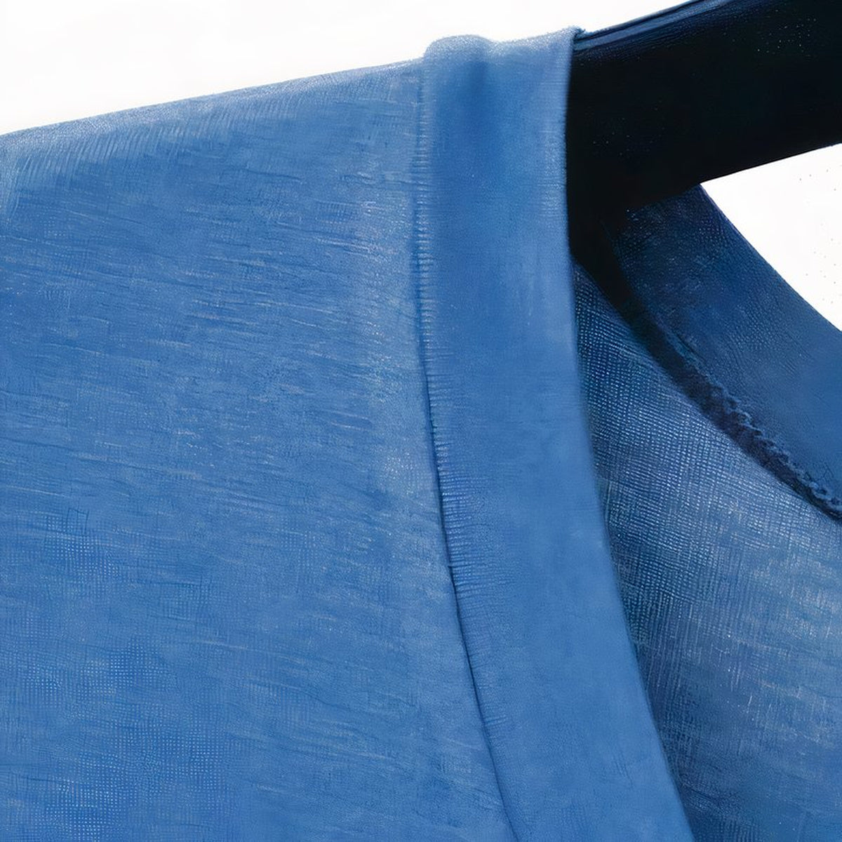 La couture d'épaule et la trame fine du tissu bleu