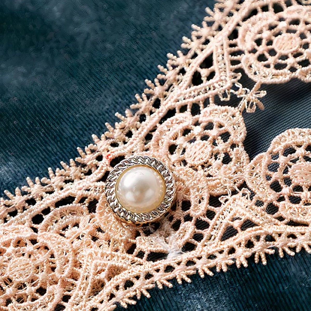 Le bouton de nacre serti, au creux du décolleté