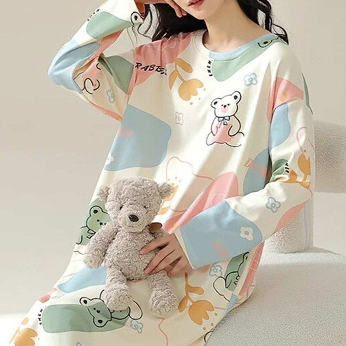 Détail du tissu moelleux de la chemise de nuit et de l'ourson en peluche assorti Image