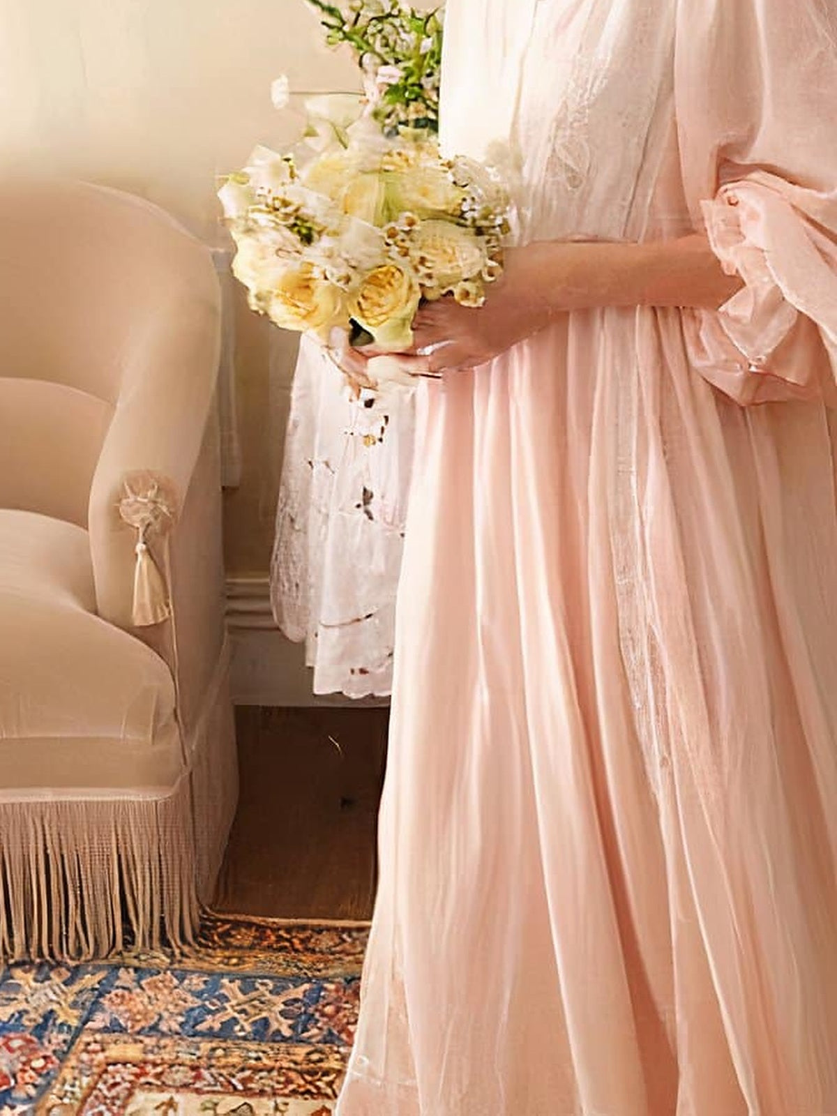 Chemise de nuit rose portee dans un interieur clair, bouquet a la main