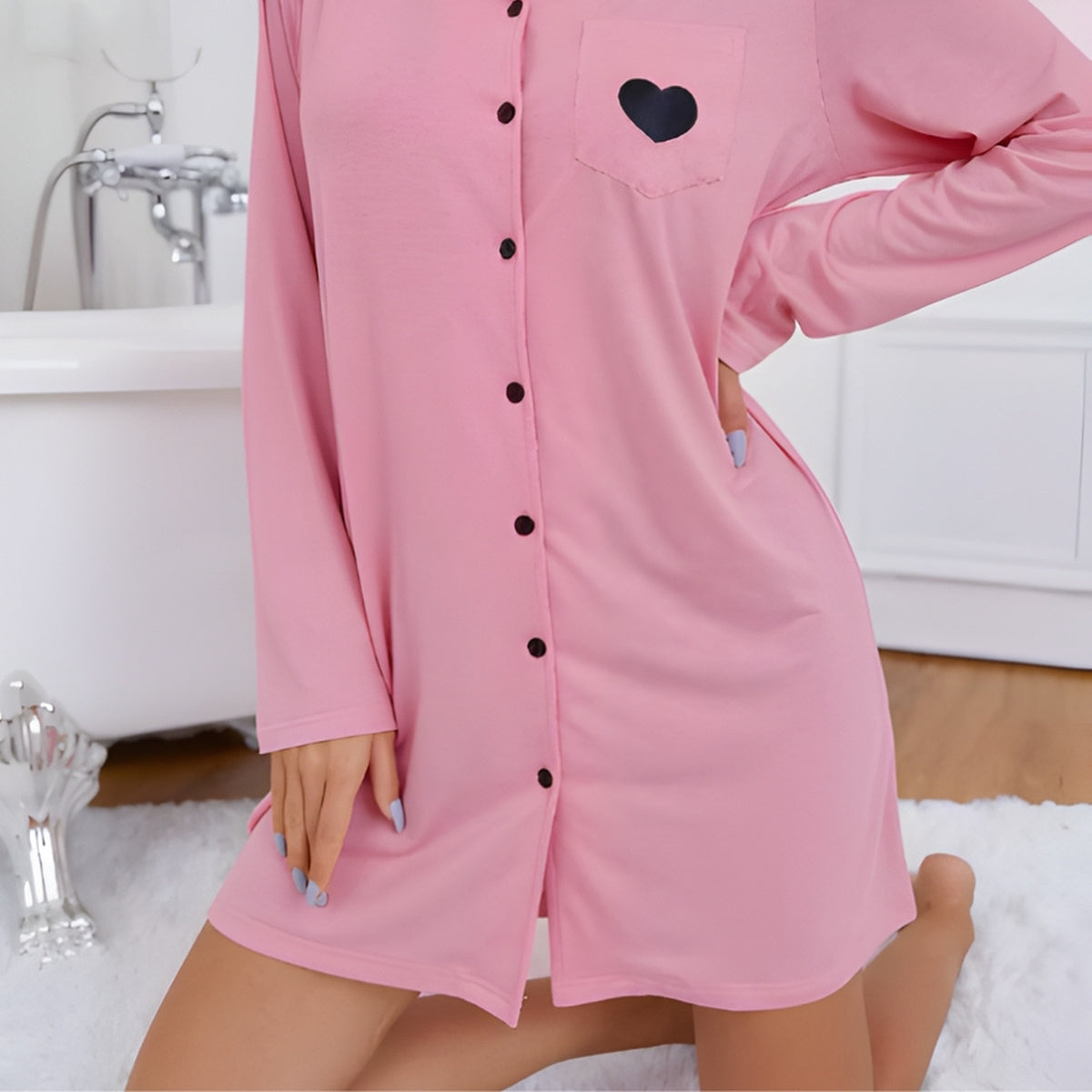 Détail de la chemise de nuit rose, avec poche à cœur, boutons noirs et bas arrondi
