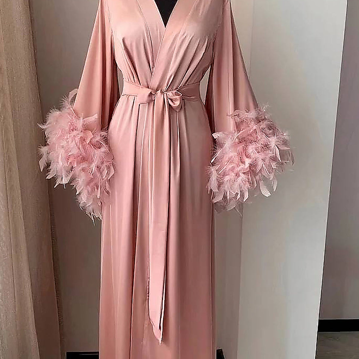 Le col croisé du peignoir en rose et sa ceinture