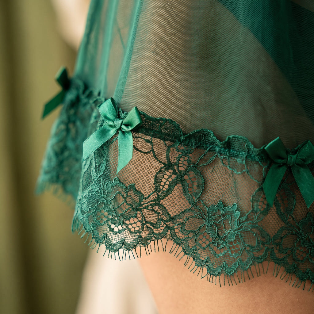 Détail de l'ourlet festonné en dentelle verte transparente