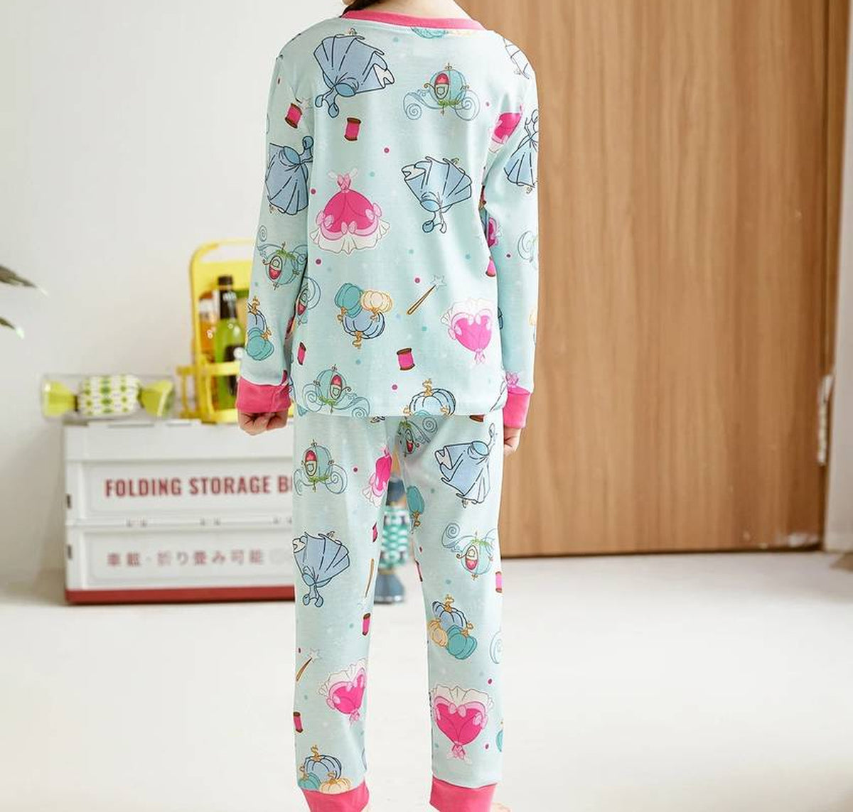 Dos du pyjama fille porté, imprimé de robes de bal et de carrosses sur le haut et sur le pantalon
