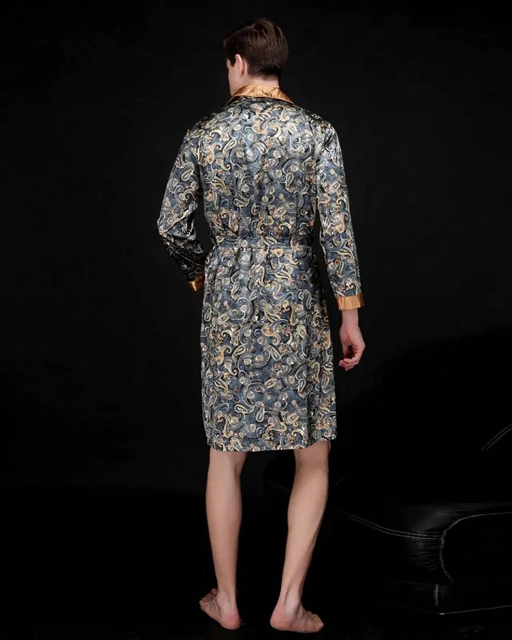 Robe de chambre satinée grise portée de dos, motif paisley jusque dans le dos, poignet doré et ourlet au genou