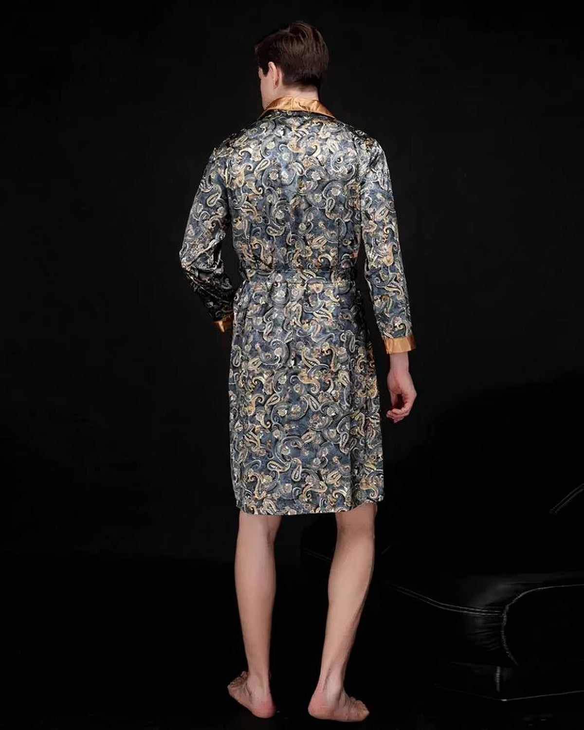 Robe de chambre satinée grise portée de dos, motif paisley jusque dans le dos, poignet doré et ourlet au genou