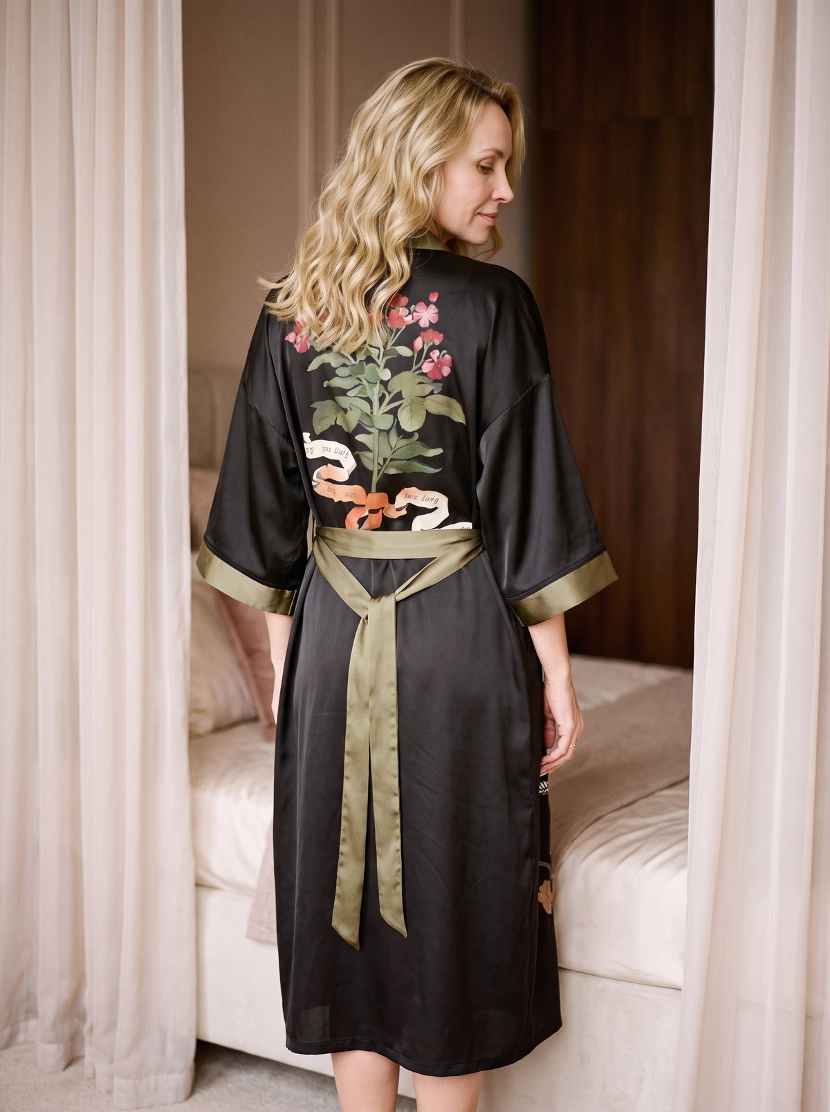 Peignoir kimono noir porté de dos, grand bouquet fleuri entre les épaules et ceinture vert kaki nouée dans le dos